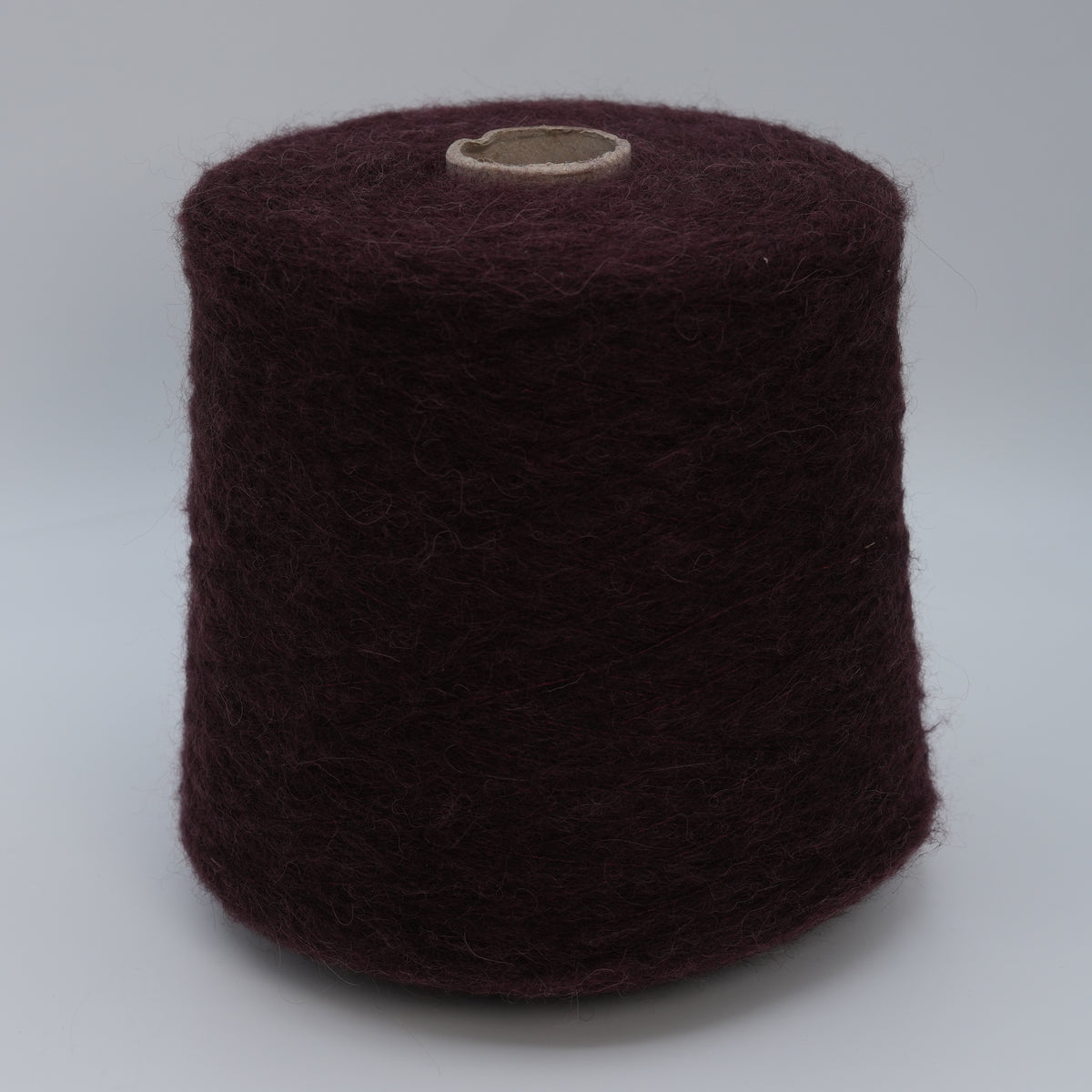 Cone of Nuage 8100 fluffy alpaca blend yarn in Dark Burgundy.