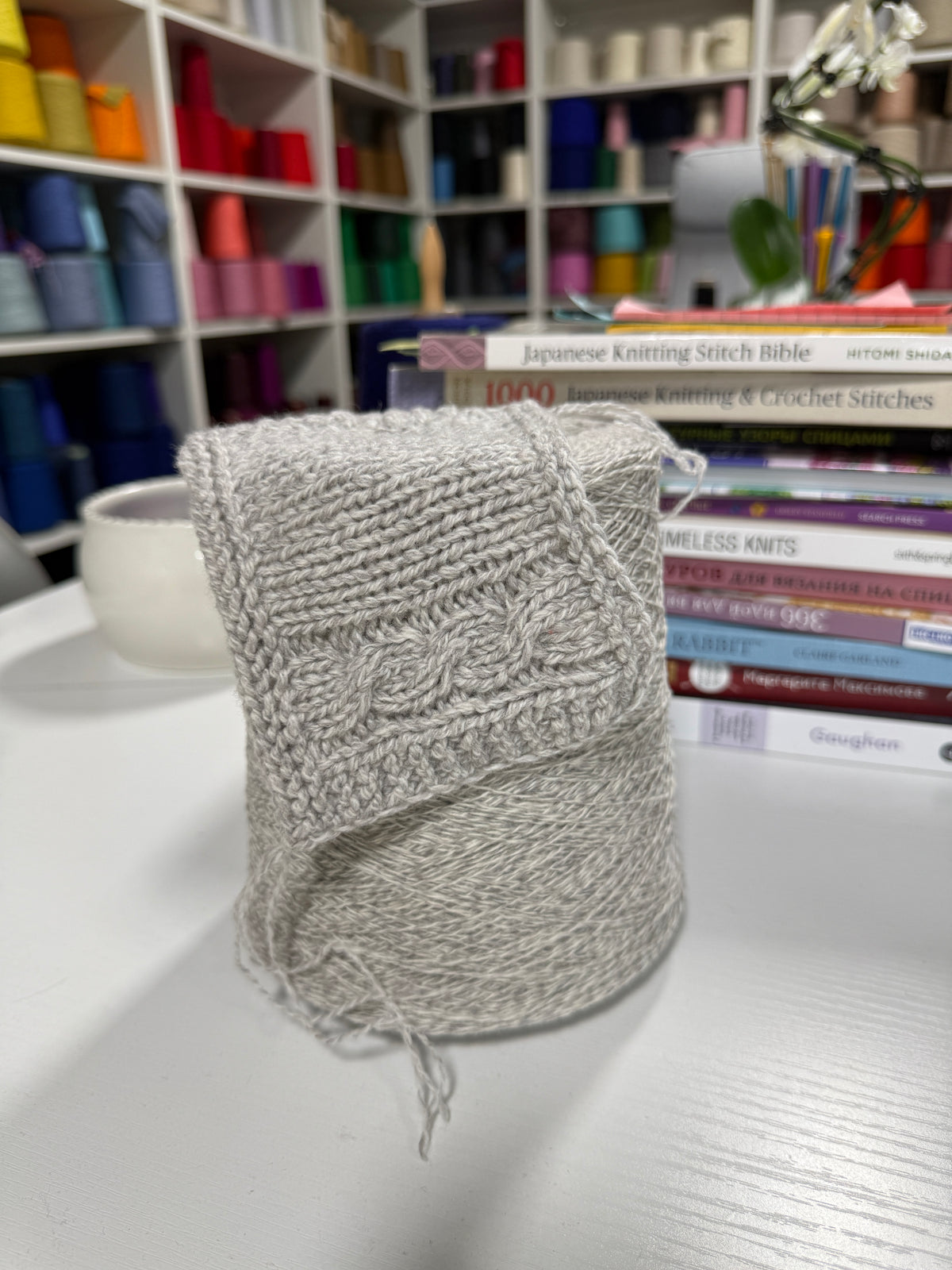 Cone and knitted swatch of Orchidea 2/15000 merino and polyamide blend yarn in Pale Heather.