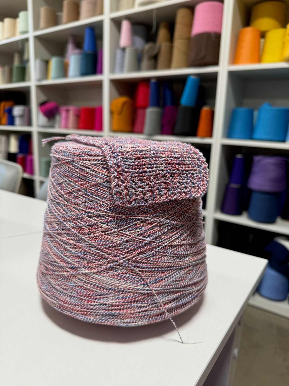 Cone and knitted swatch of BemyBaby 100% cotton yarn in Americana Twist.