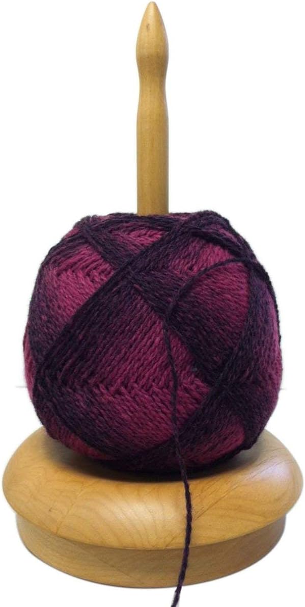 ChiaoGoo wooden Yarn Butler holding a purple yarn ball on a smooth rotating spindle base