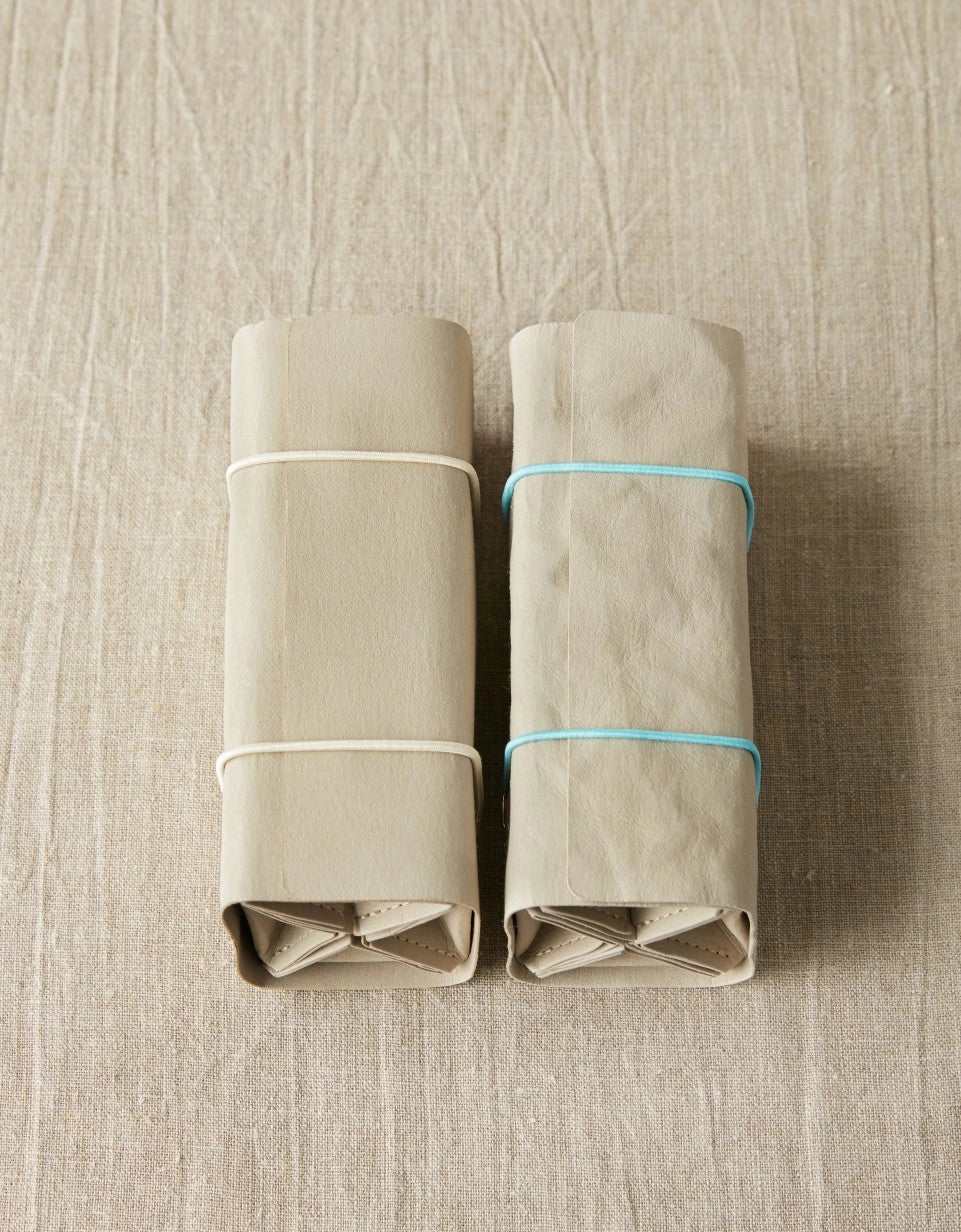 Cocoknits Accessory Roll in Gray partially rolled with adjustable elastic closure and storage pouches visible