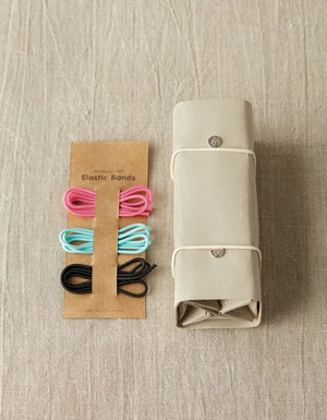 Cocoknits Accessory Roll in Gray displayed beside colorful knitting notions to show compact accessory storage