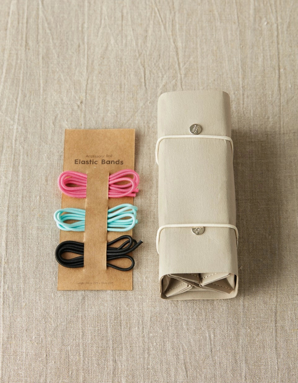 Cocoknits Accessory Roll in Gray displayed beside colorful knitting notions to show compact accessory storage