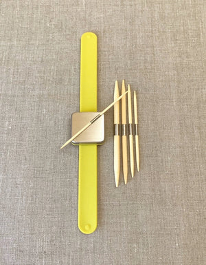 Cocoknits Bamboo Cable Needles held by their magnetic steel bands on a Maker's Keep wristband