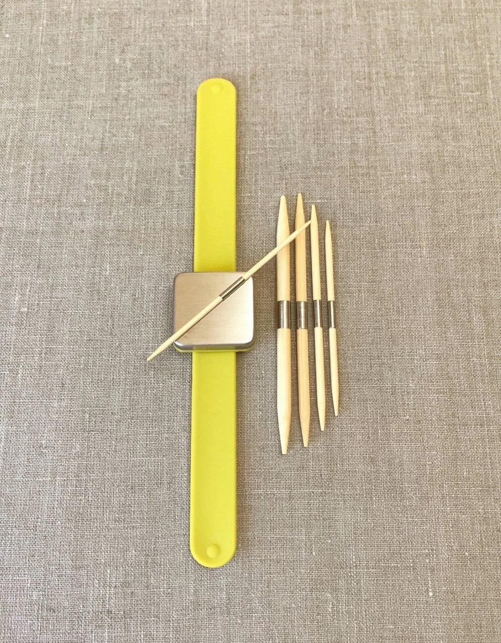 Cocoknits Bamboo Cable Needles held by their magnetic steel bands on a Maker's Keep wristband