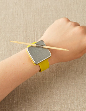 Cocoknits Bamboo Cable Needles attached magnetically to a Maker's Keep bracelet for convenient access while knitting
