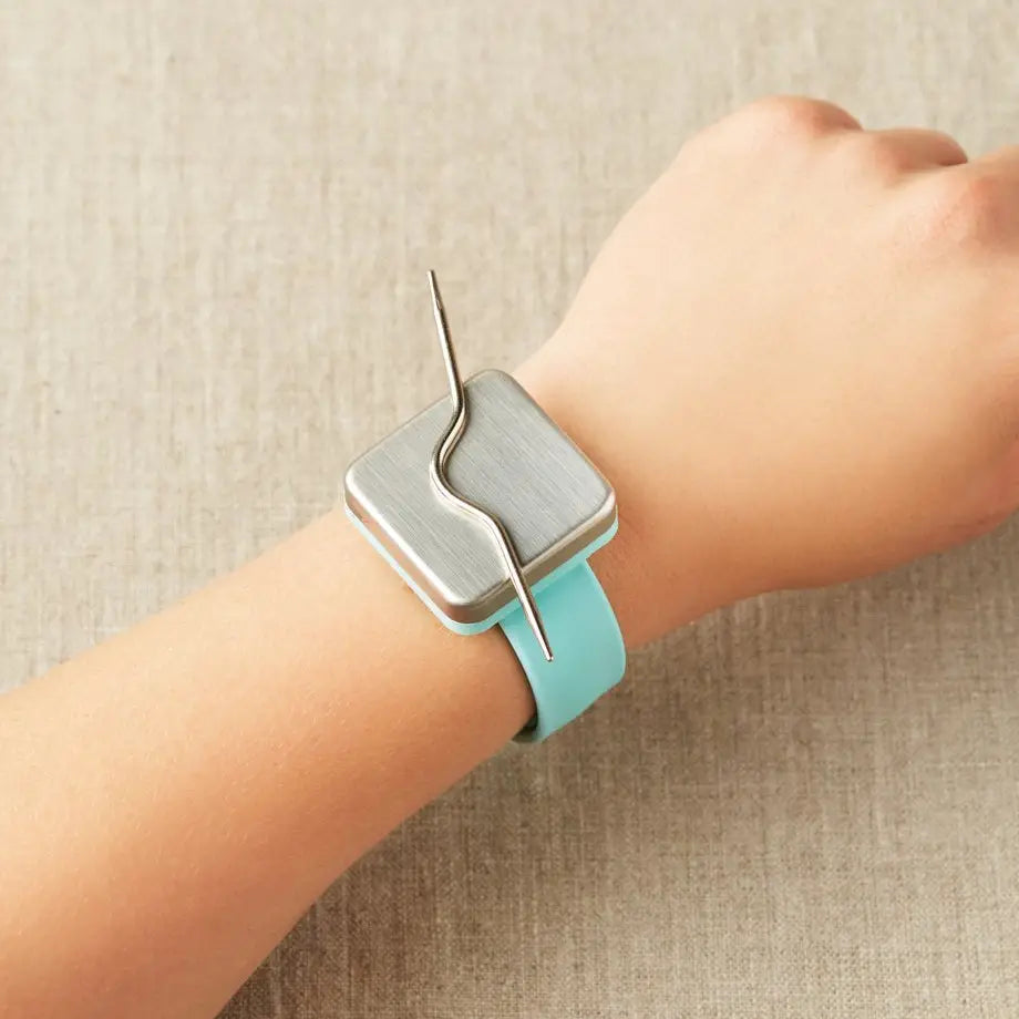 Cocoknits Curved Cable Needles attached magnetically to a Maker's Keep wristband for easy access