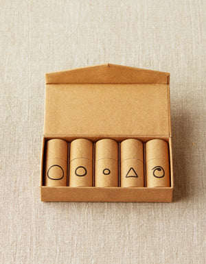 Cocoknits Flight of Stitch Markers with five labeled tubes in an open kraft storage box