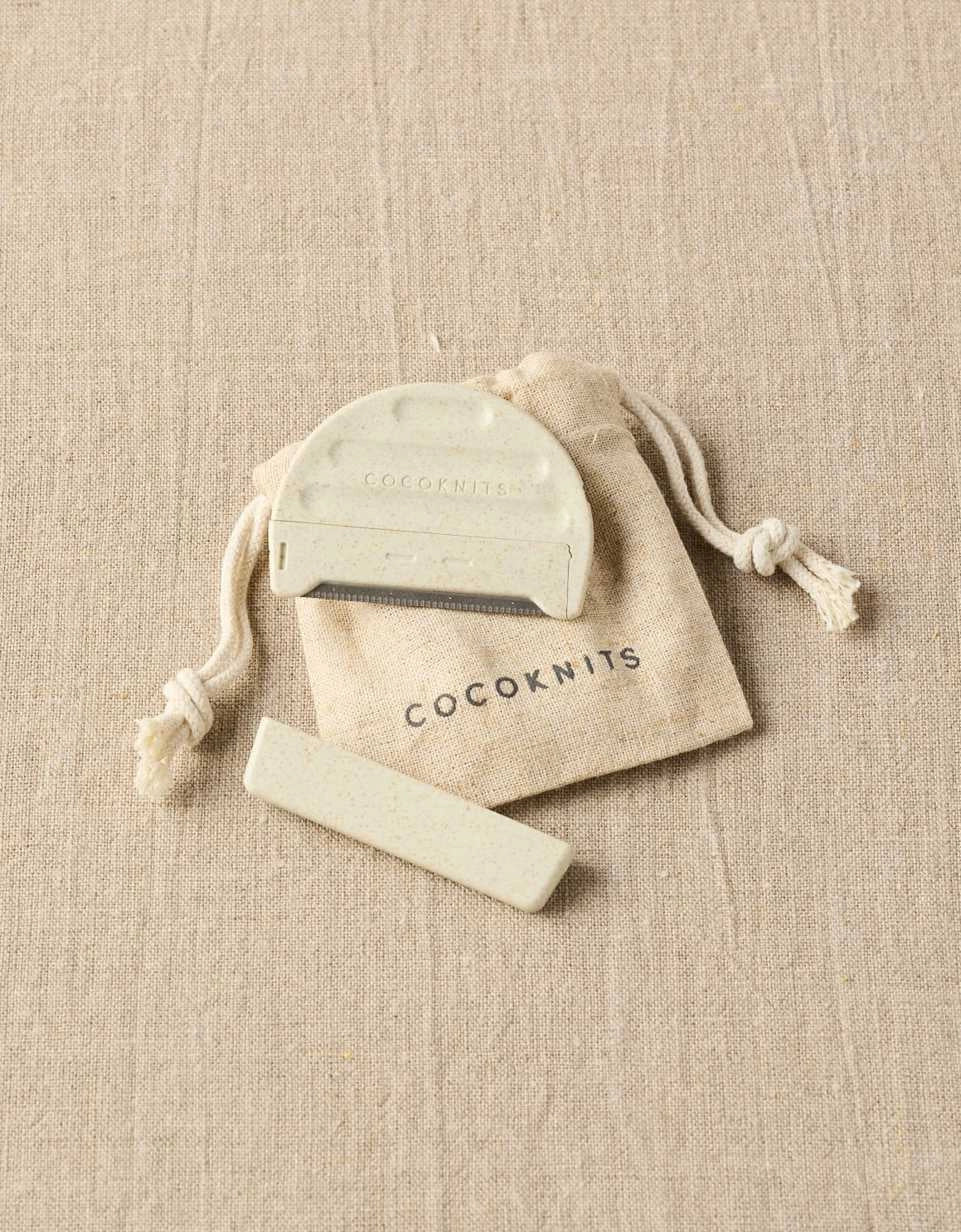 Cocoknits Fuzz Off Comb II arranged with its drawstring storage pouch and accessories