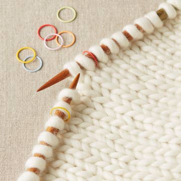 Cocoknits Jumbo Ring Stitch Markers on a knitting needle showing their oversized design