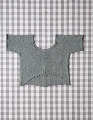 Knitted sweater arranged on the Cocoknits Knitter's Block Kit gingham grid cloth for blocking