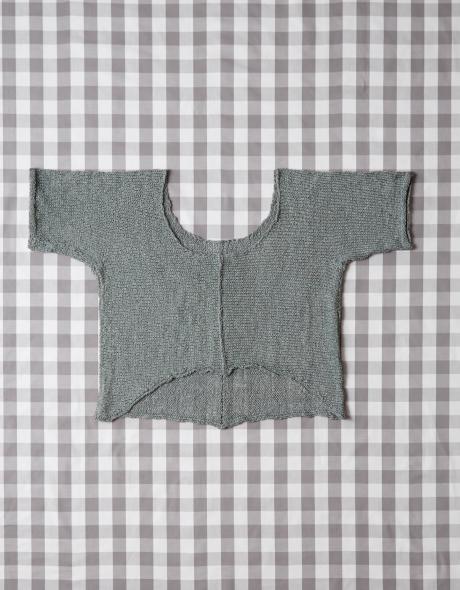 Knitted sweater arranged on the Cocoknits Knitter's Block Kit gingham grid cloth for blocking