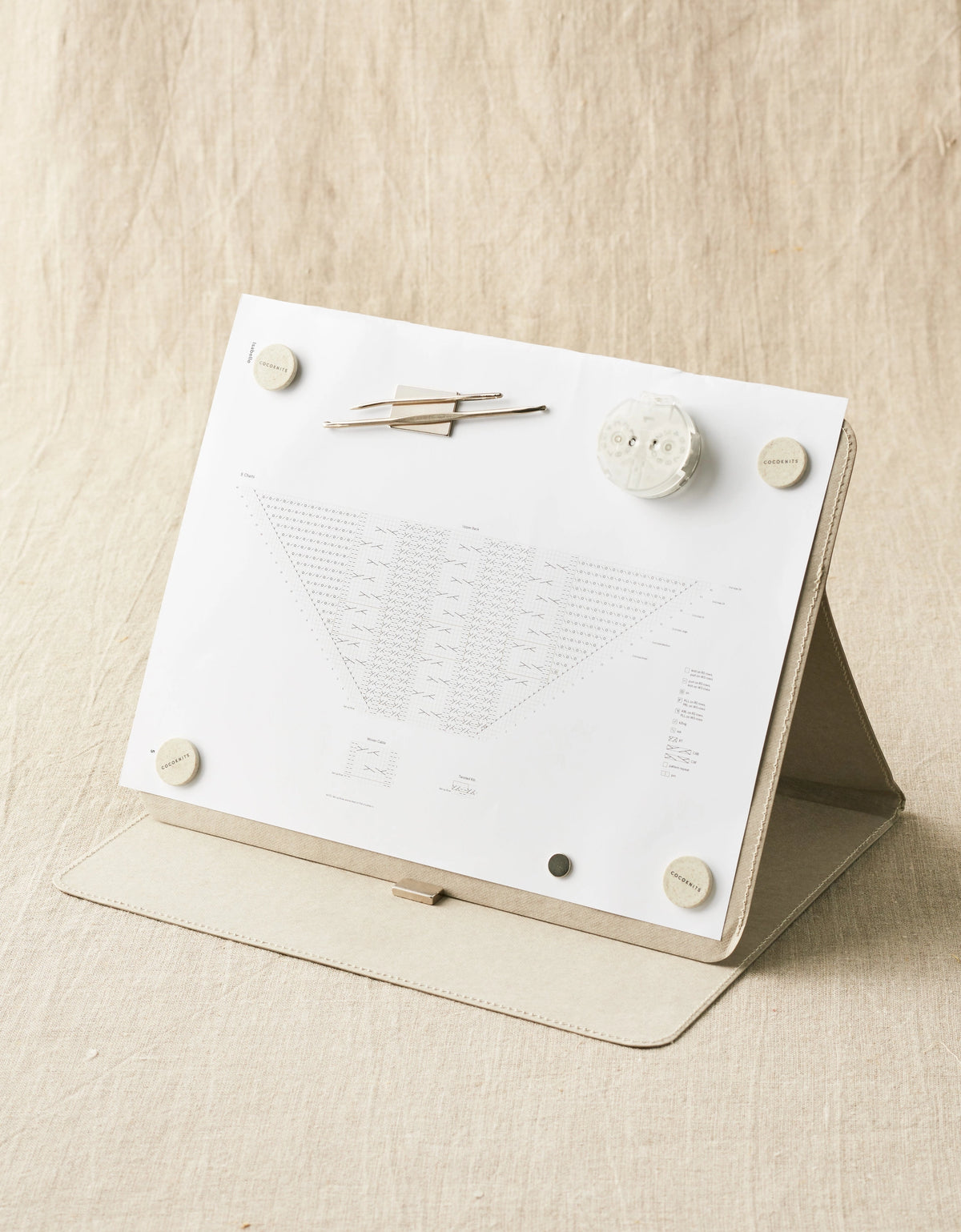 Cocoknits Maker's Board in Gray standing upright with a knitting pattern secured by magnets