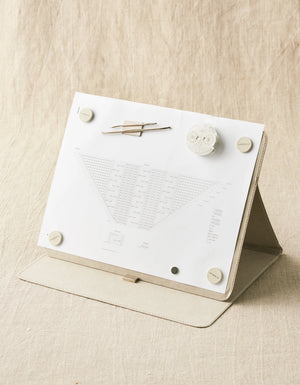 Cocoknits Maker's Board in Gray standing upright with a knitting pattern secured by magnets