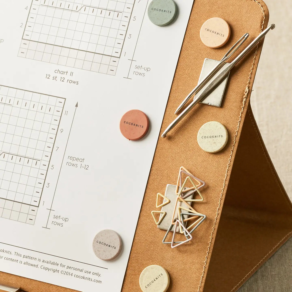 Cocoknits Maker's Board in Kraft holding a knitting pattern with magnetic tools and notions