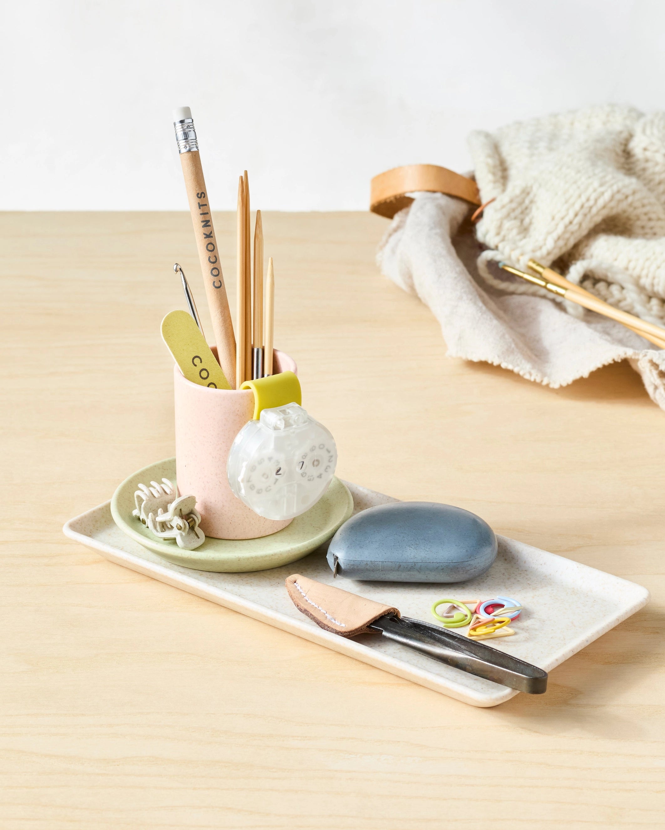 Cocoknits Notions Holder Cup with knitting tools on a wooden workspace