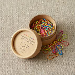 Cocoknits Colorful Opening Stitch Markers displayed beside their wooden storage tin