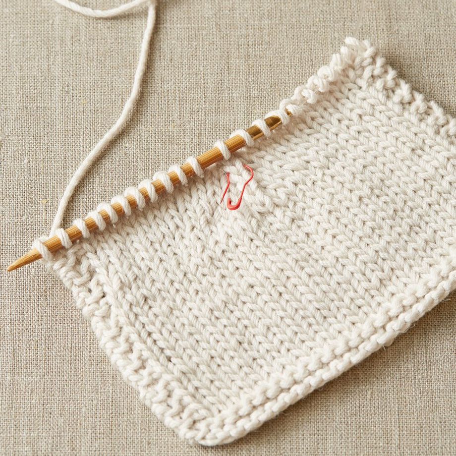 Cocoknits Colorful Opening Stitch Marker attached directly to a knitted project for tracking rows and stitches