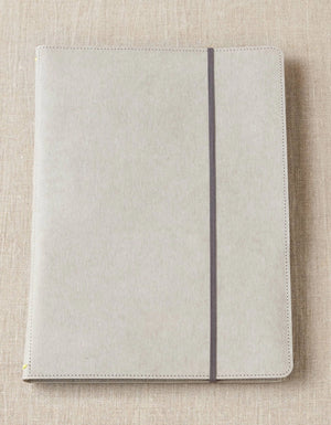 Closed Cocoknits Project Portfolio with elastic band on a beige linen background