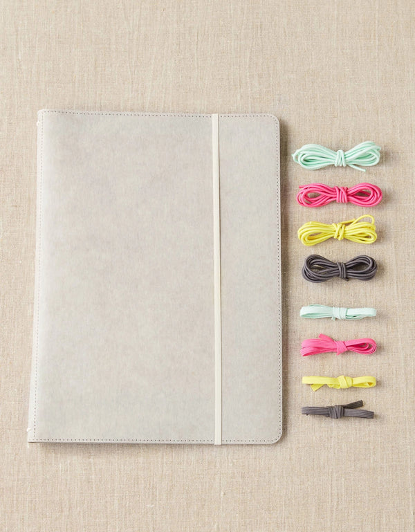 Cocoknits Project Portfolio with colorful stitch holders on a beige linen background
