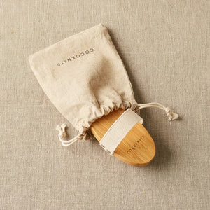 Cocoknits Sweater Care Brush. Wooden brush partly removed from its drawstring storage bag.