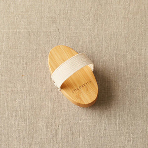 Cocoknits Sweater Care Brush. Wooden brush showing its hand strap.