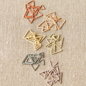 Cocoknits Triangle Stitch Markers displayed in a muted selection of warm and cool earth tone colors