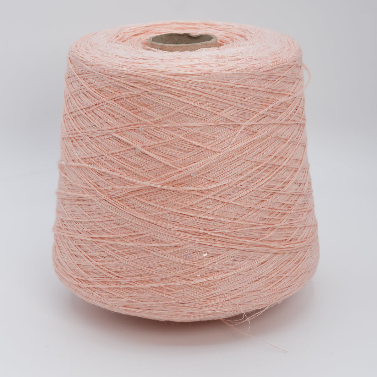 Cone of Lino 4200 linen yarn in Salmon Sequin, a soft salmon pink with scattered sequins, on a white background.