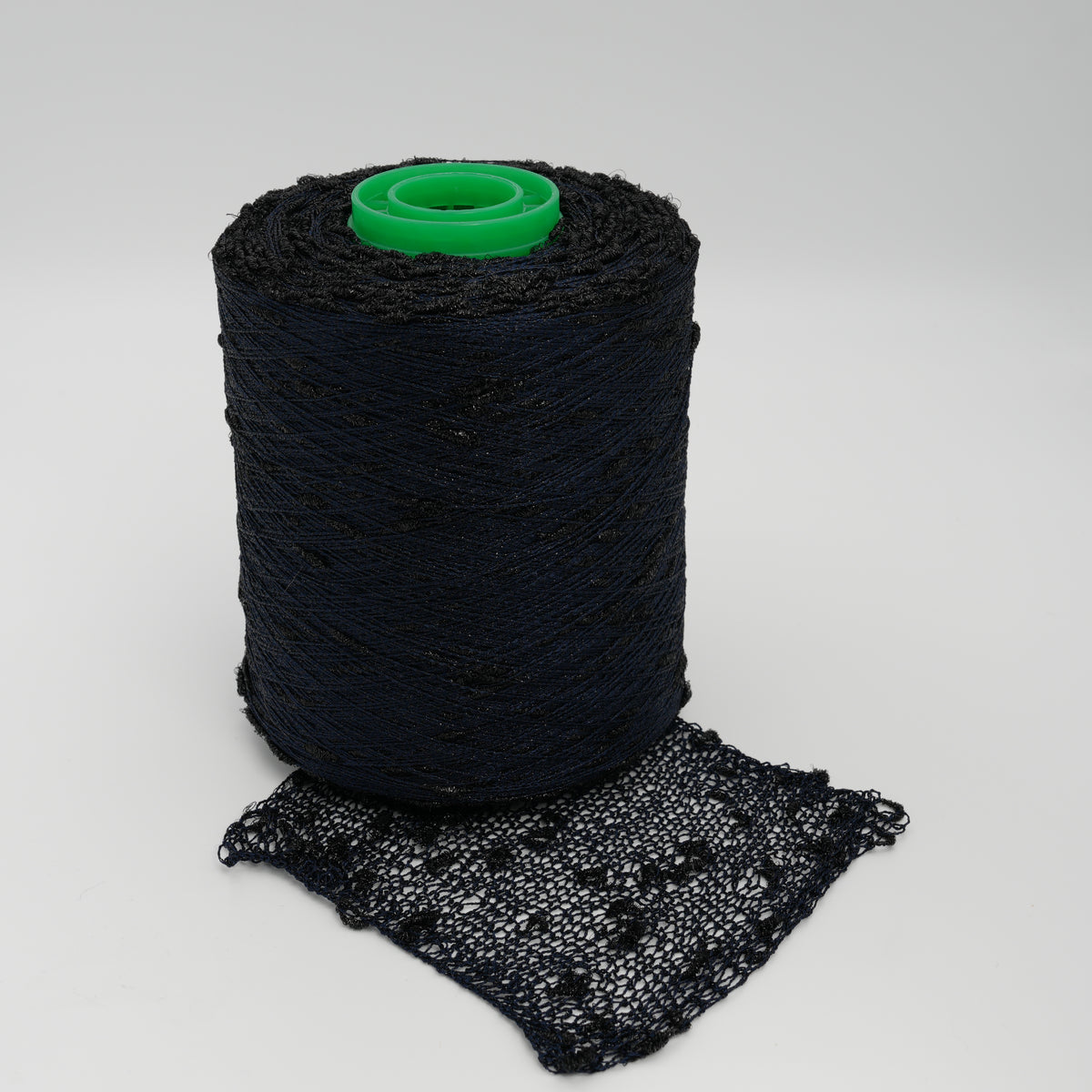 Cone and knitted swatch of Luckystar 6000 viscose and slubbed lurex blend yarn in black.