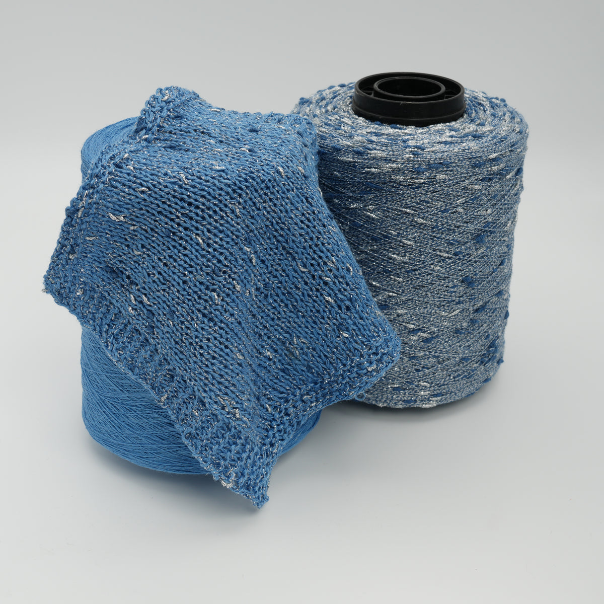 Cone and knitted swatch of Luckystar 6000 viscose and slubbed lurex blend yarn in blue.