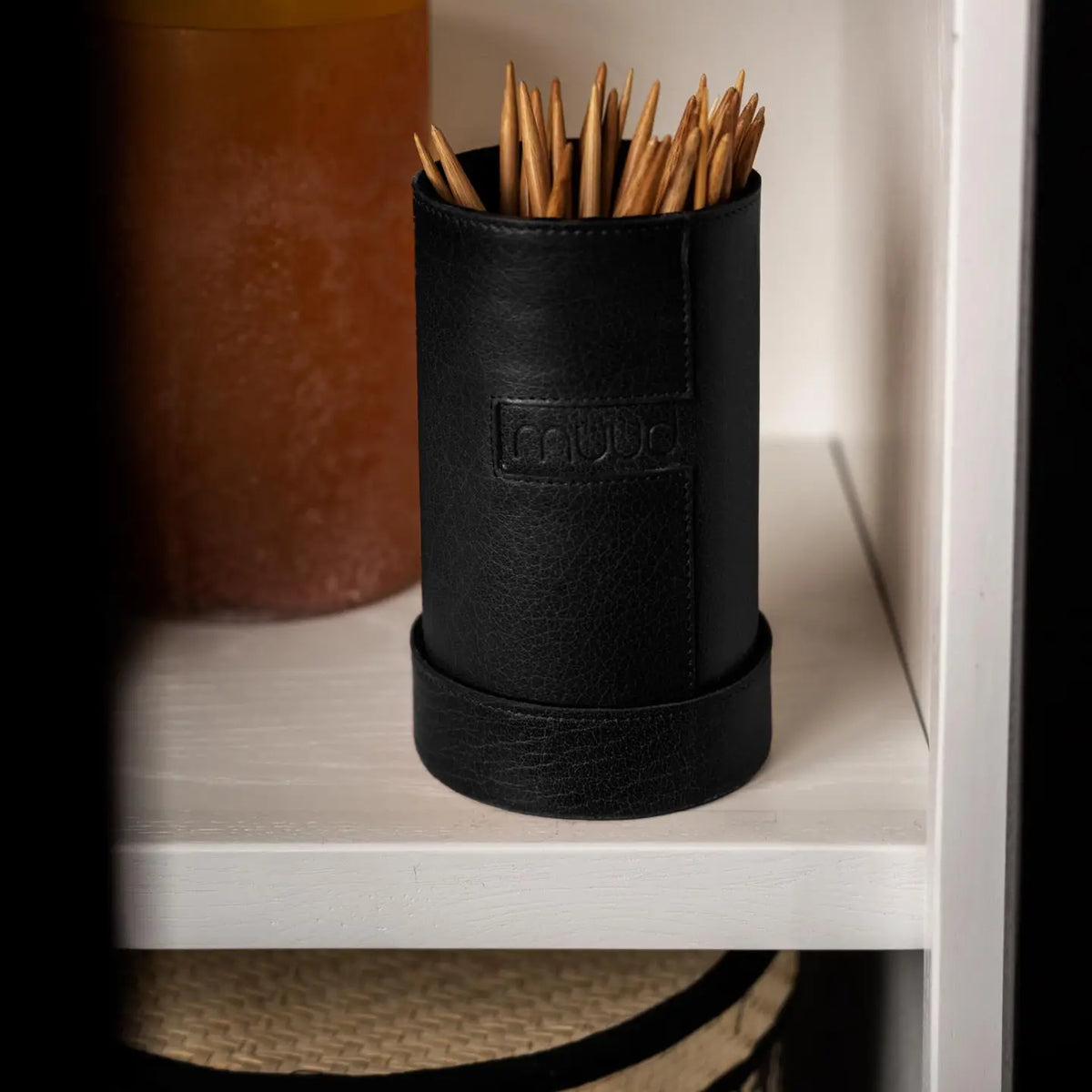 Muud Mountain Cannister | Genuine Leather in Black. Leather needle case on a shelf holding knitting needles.