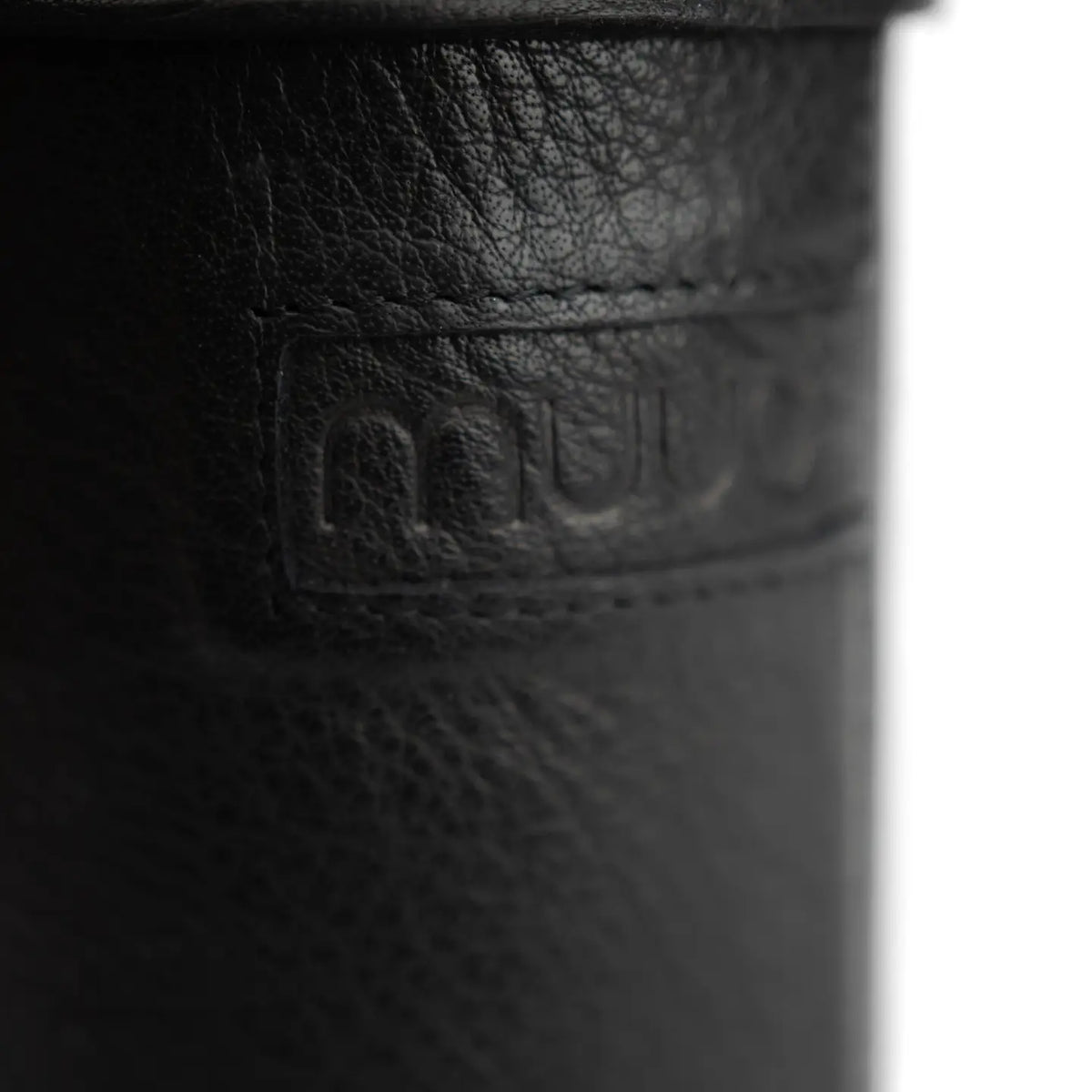 Muud Mountain Cannister | Genuine Leather in Black. Close-up of the leather grain and embossed label.