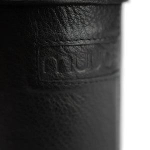 Muud Mountain Cannister | Genuine Leather in Black. Close-up of the leather grain and embossed label.