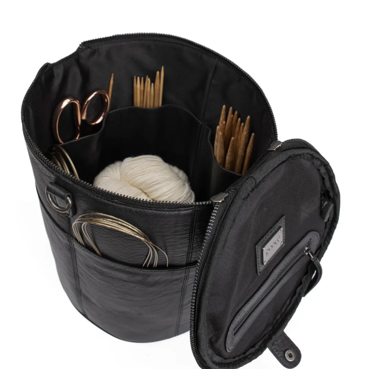 Muud Saturn XL Leather Project Bag in Black. Open bag holding yarn, needles and scissors.