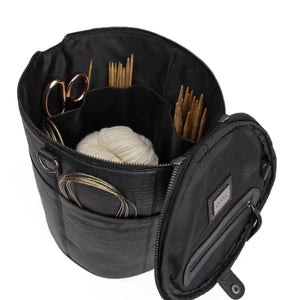 Muud Saturn XL Leather Project Bag in Black. Open bag holding yarn, needles and scissors.