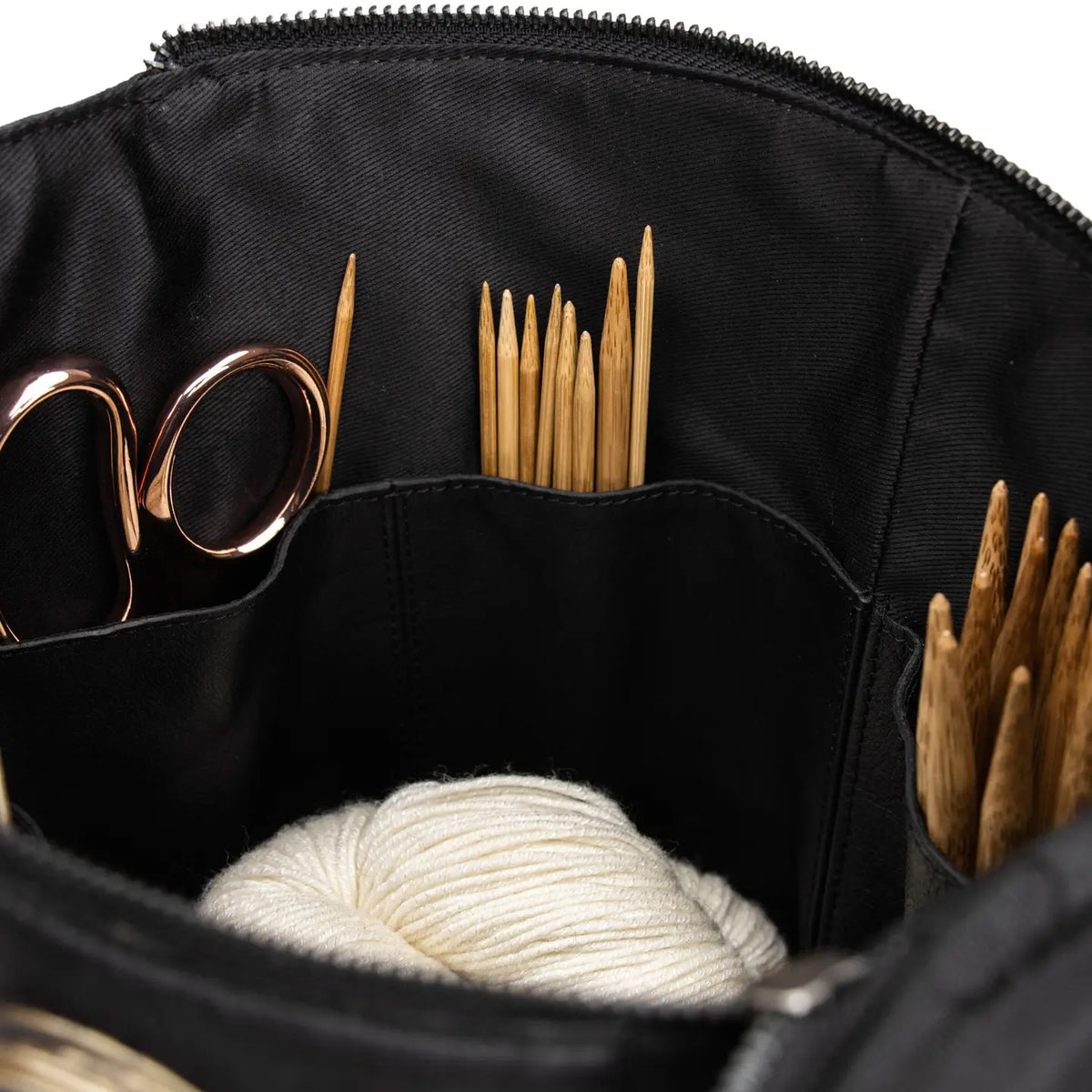 Muud Saturn XL Leather Project Bag in Black. Close-up of interior storage holding needles, scissors and yarn.