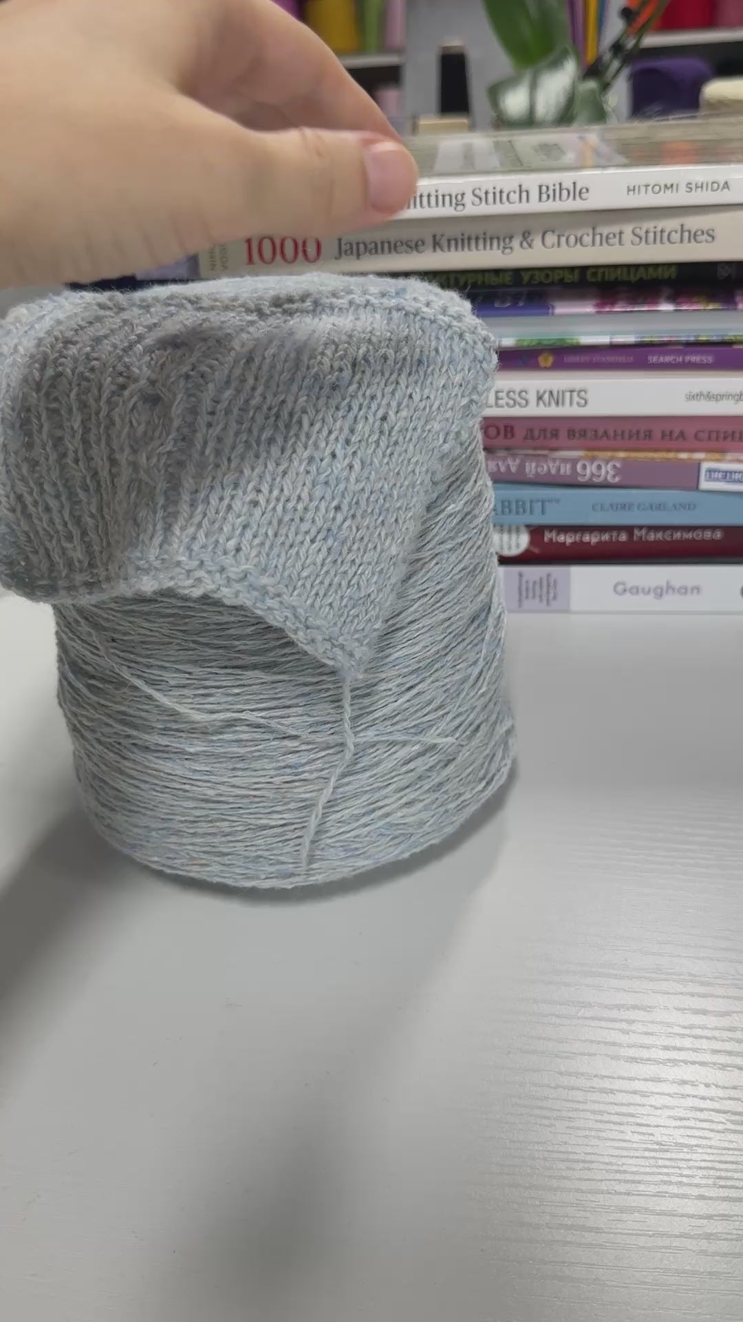 Video showing cone and knitted swatch of Monviso 2/8000 tweed wool blend yarn in gray.