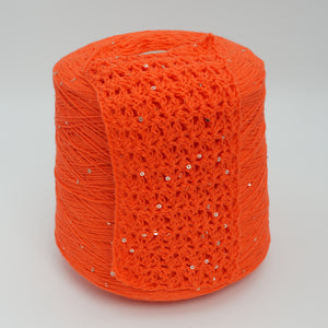 Cone and knitted swatch of Primavera NM4200 cotton and sequin blend yarn in Flame Orange.
