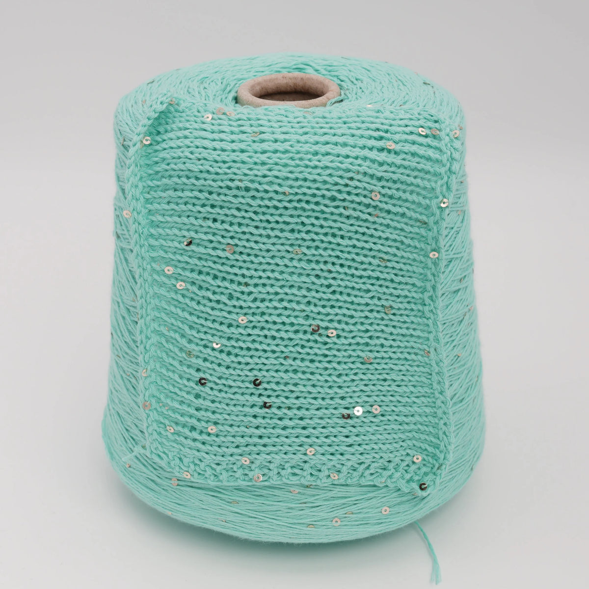 Cone and knitted swatch of Primavera NM4200 cotton and sequin blend yarn in Mint Seafoam.