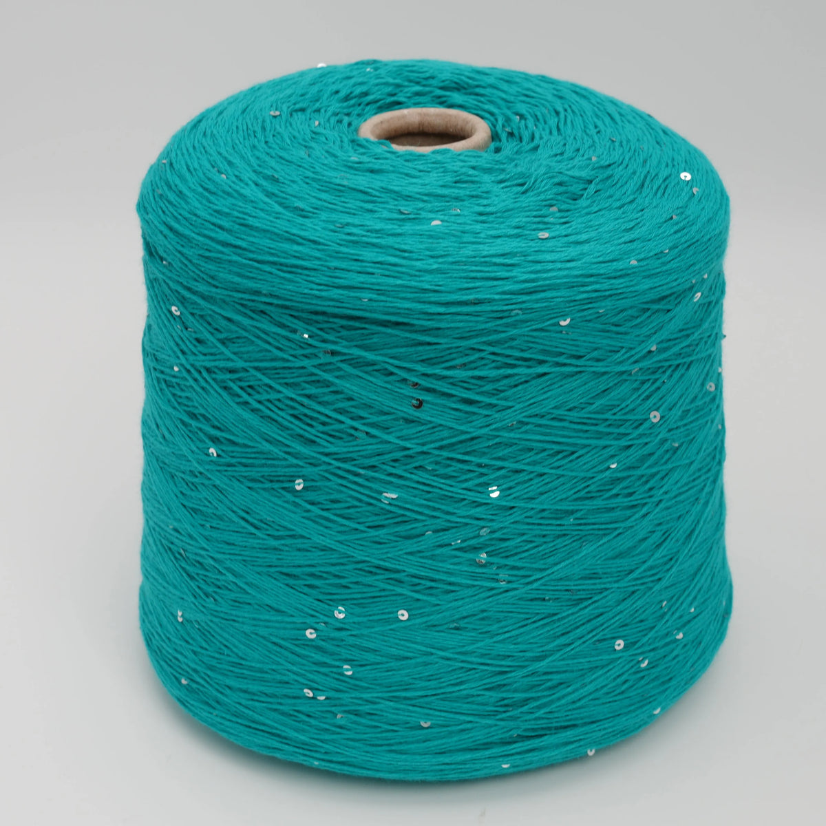 Cone of Primavera NM4200 cotton and sequin blend yarn in Tropical Teal.