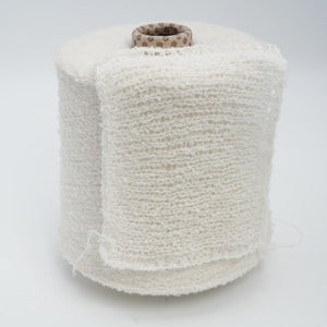 Cone and knitted swatch of Puff micro bouclé cashmere blend yarn in Milky Snow.