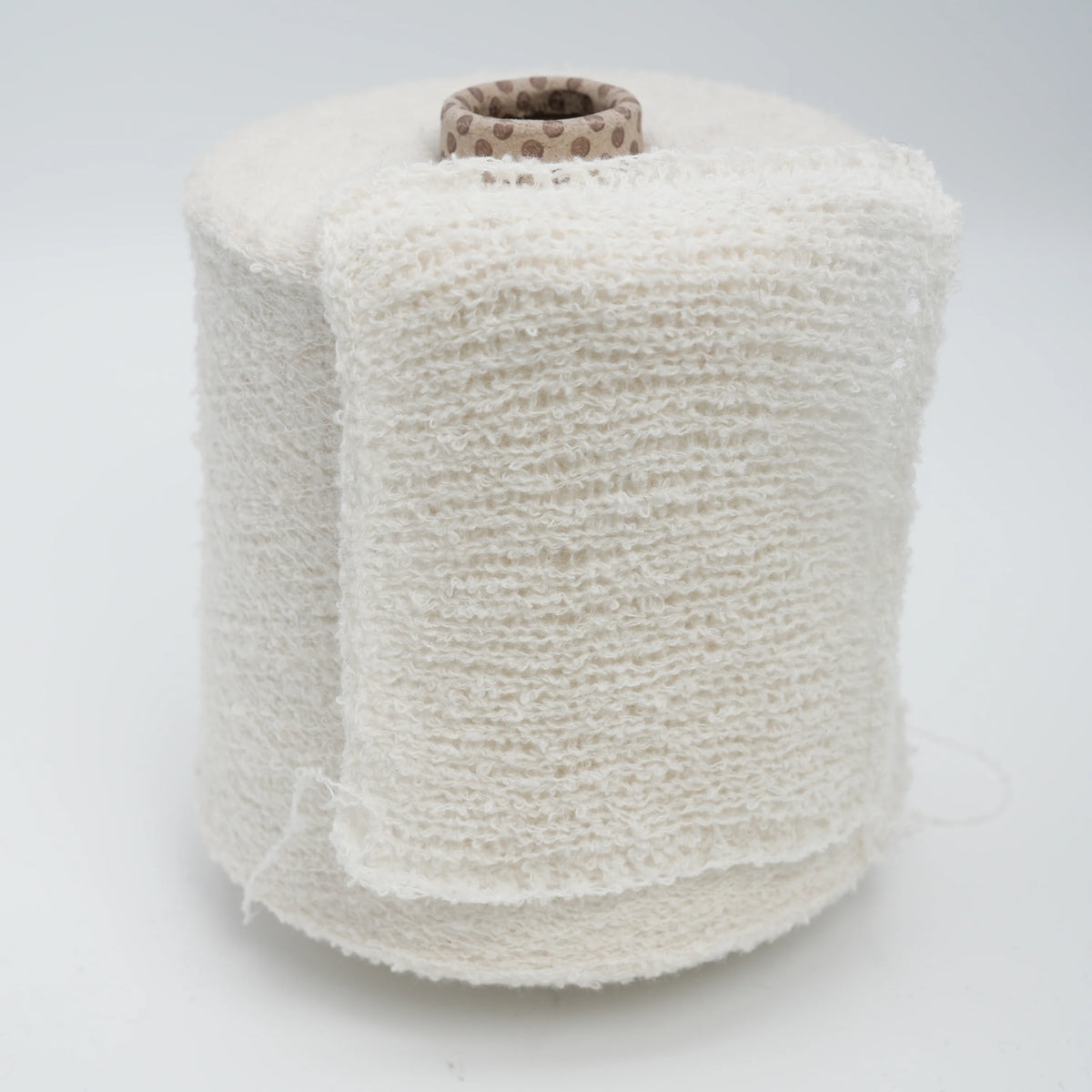 Cone and knitted swatch of Puff micro bouclé cashmere blend yarn in Milky Snow.